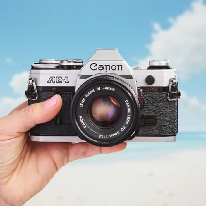 Guy wearing the Canon AE-1 camera strapped to him