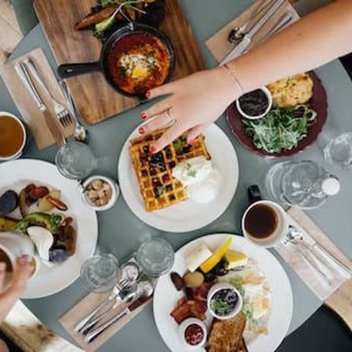 Friends eating breakfast at table with coffee