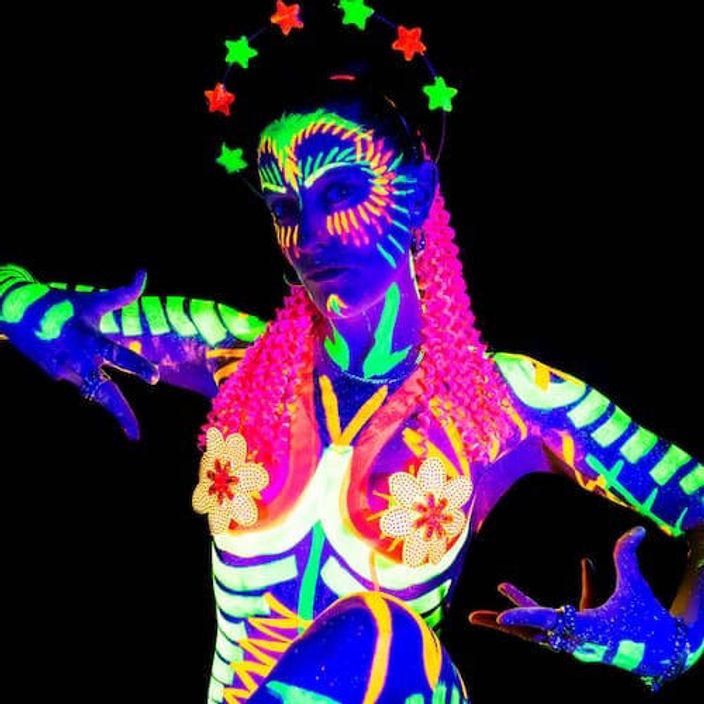 A woman covered in neon uv paint that glows in the dark