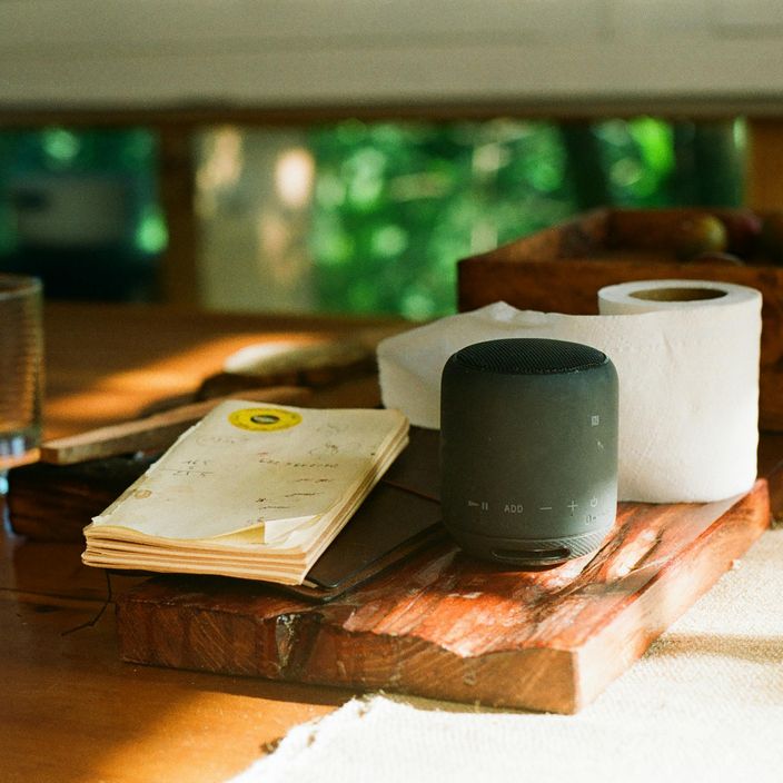 desk with notepad and wireless speaker
