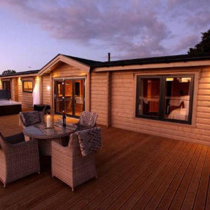 A cabin with a veranda and a hot tub