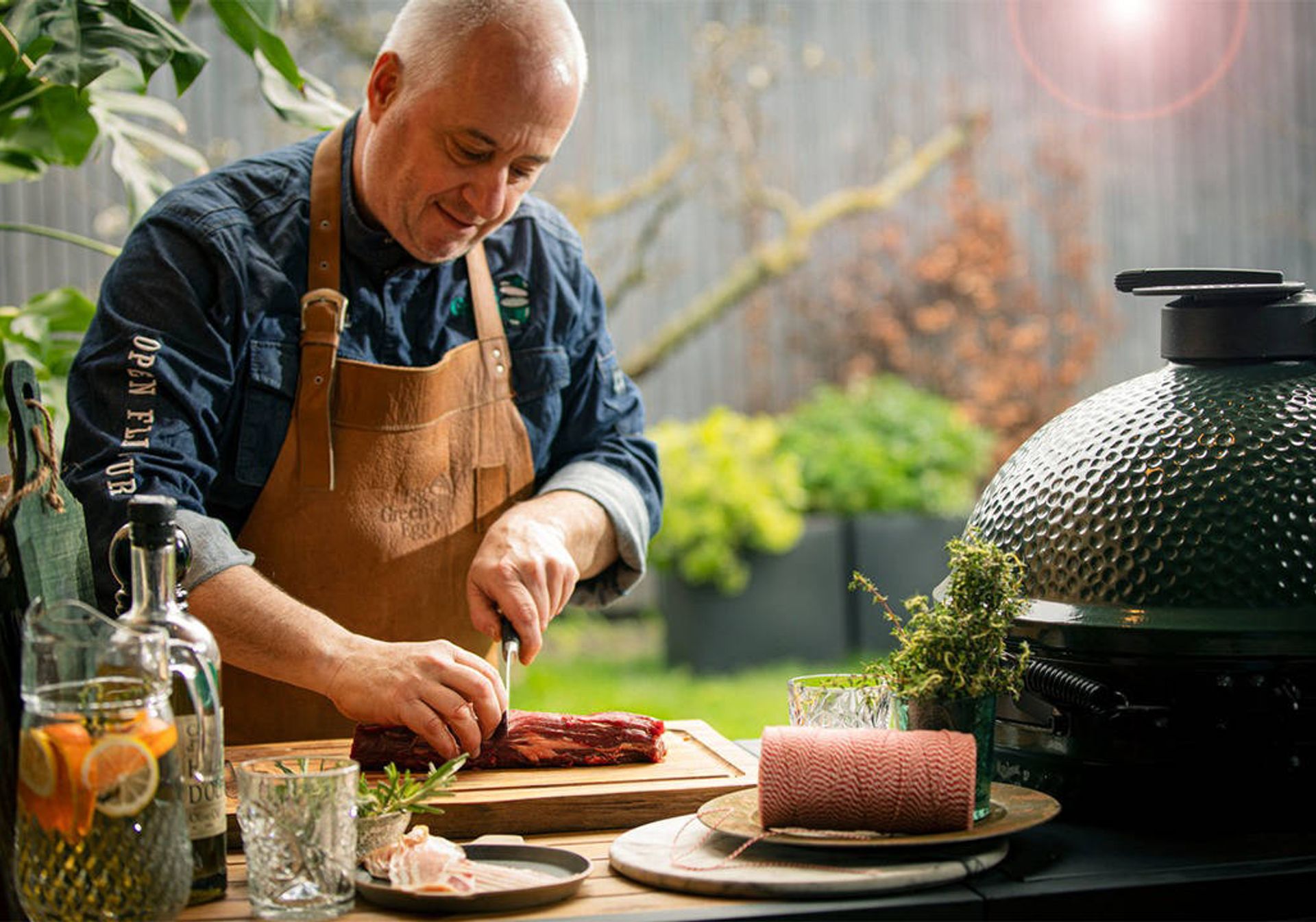 man cutting meat for the big green egg xl