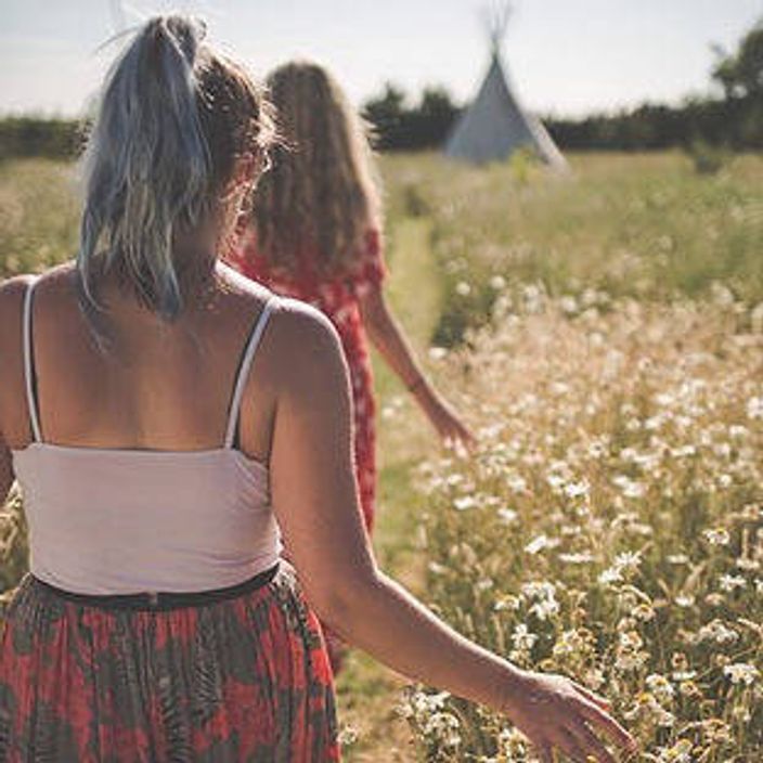 People walking through sunlit field