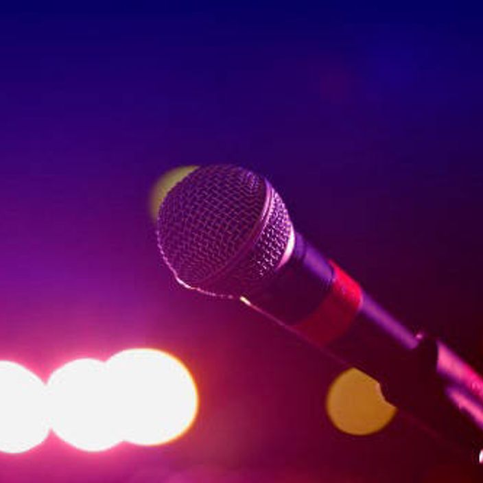 microphone with stage lighting in the background. 