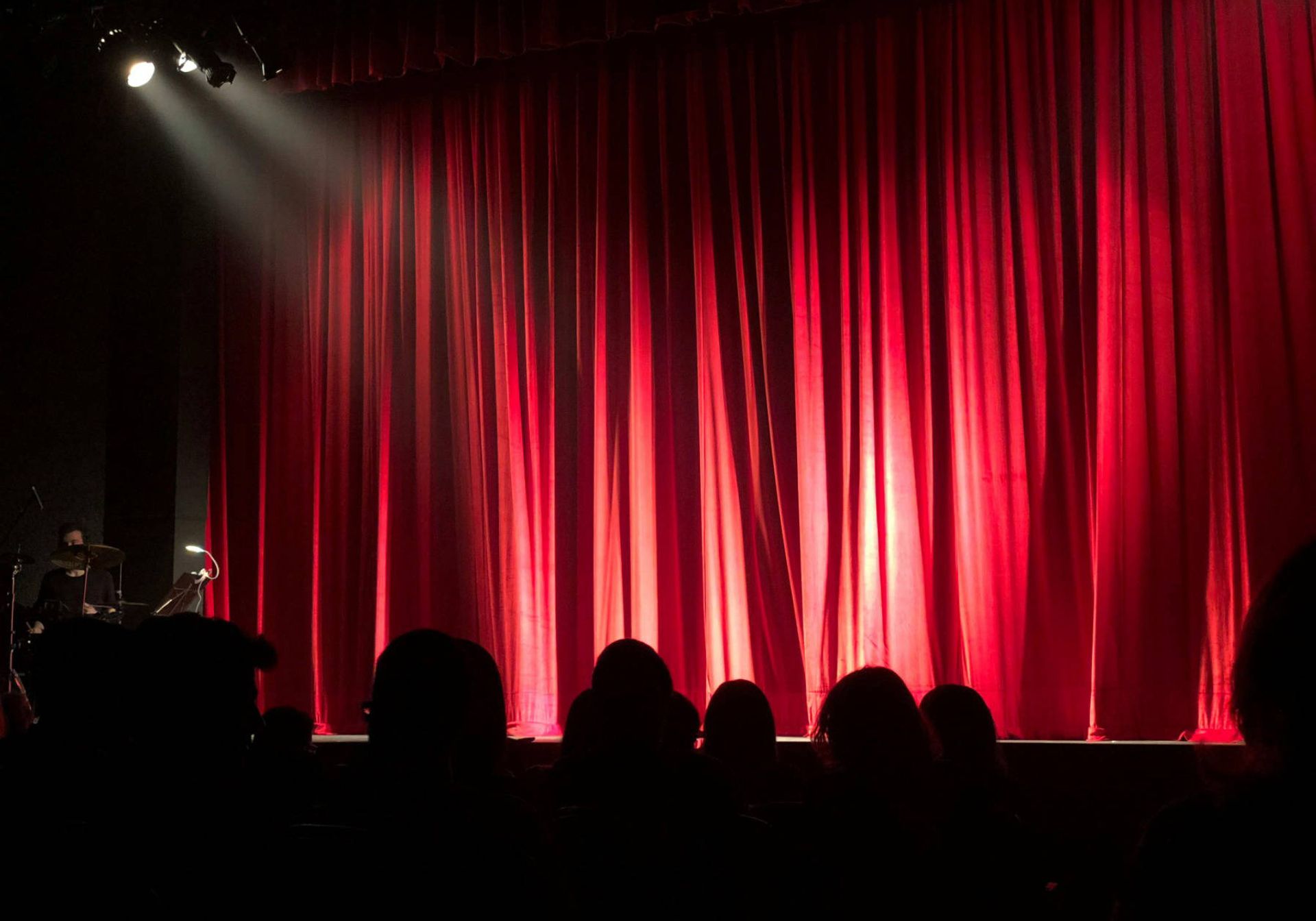red curtains with spotlight. Silhouette of heads 