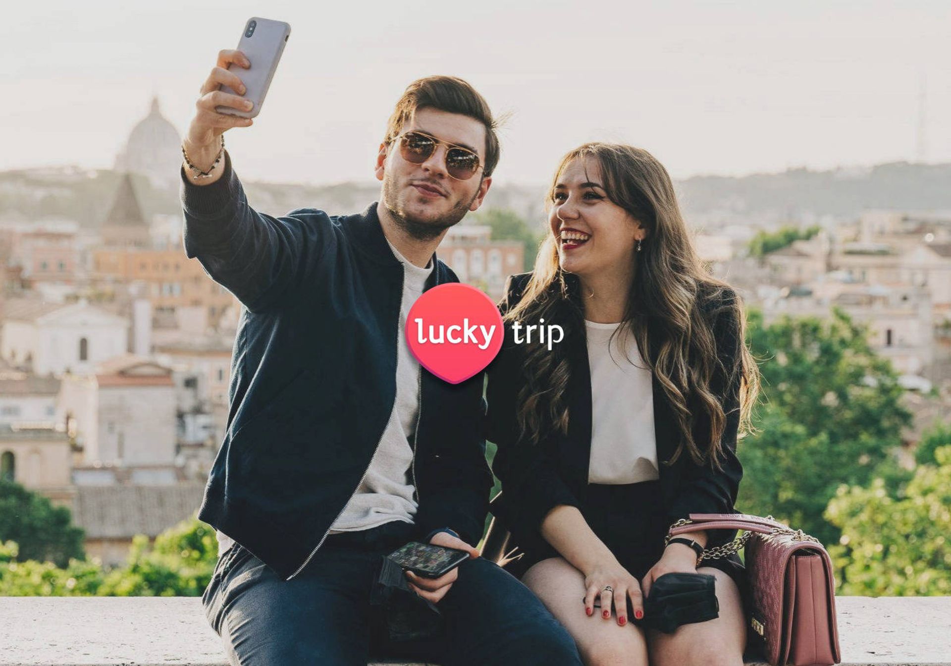 Couple taking selfie on wall of city