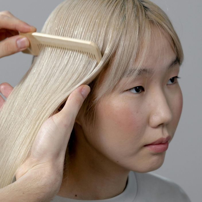 girl brushing blonde hair