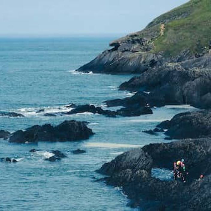 A group of people coasteering