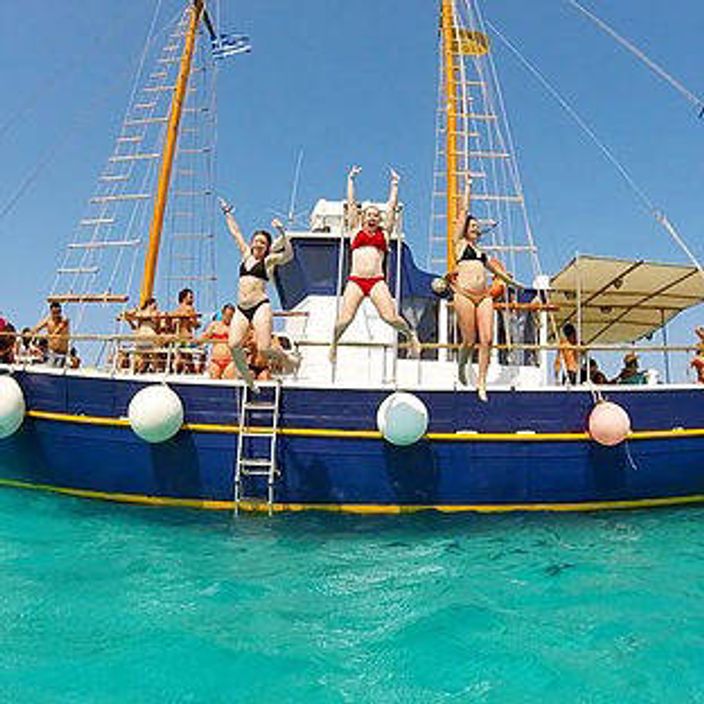 People jumping off a yacht into blue waters