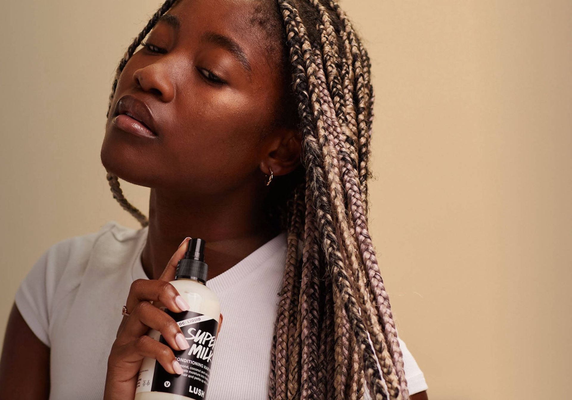 woman spraying hair milk 