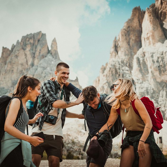 Person with a backpack stares out at a mountain landscape