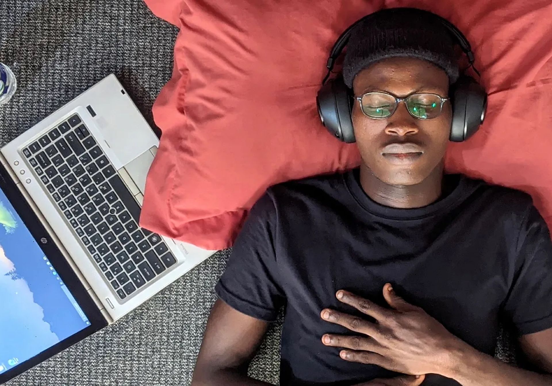 women sitting at her desk, relaxed with headphones on