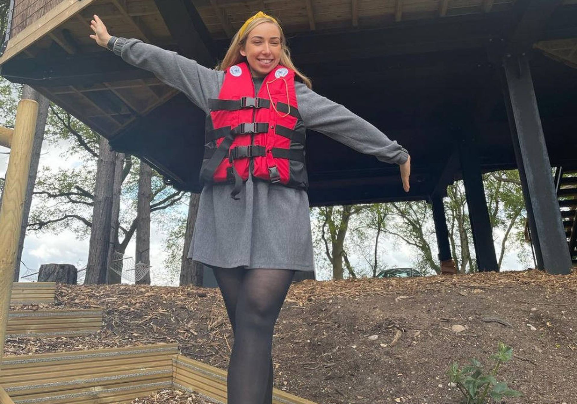 Woman in life jacket in front of tree house