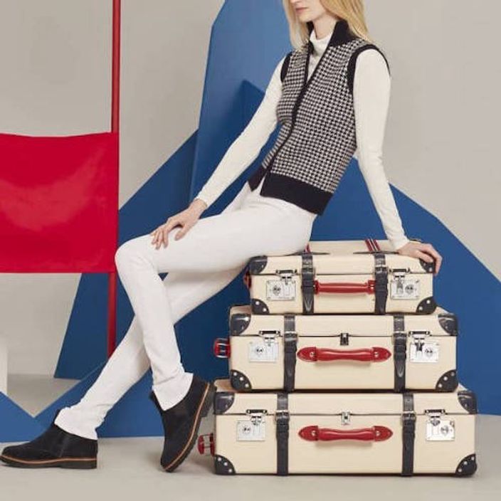 Woman on a pile of luxury suitcases