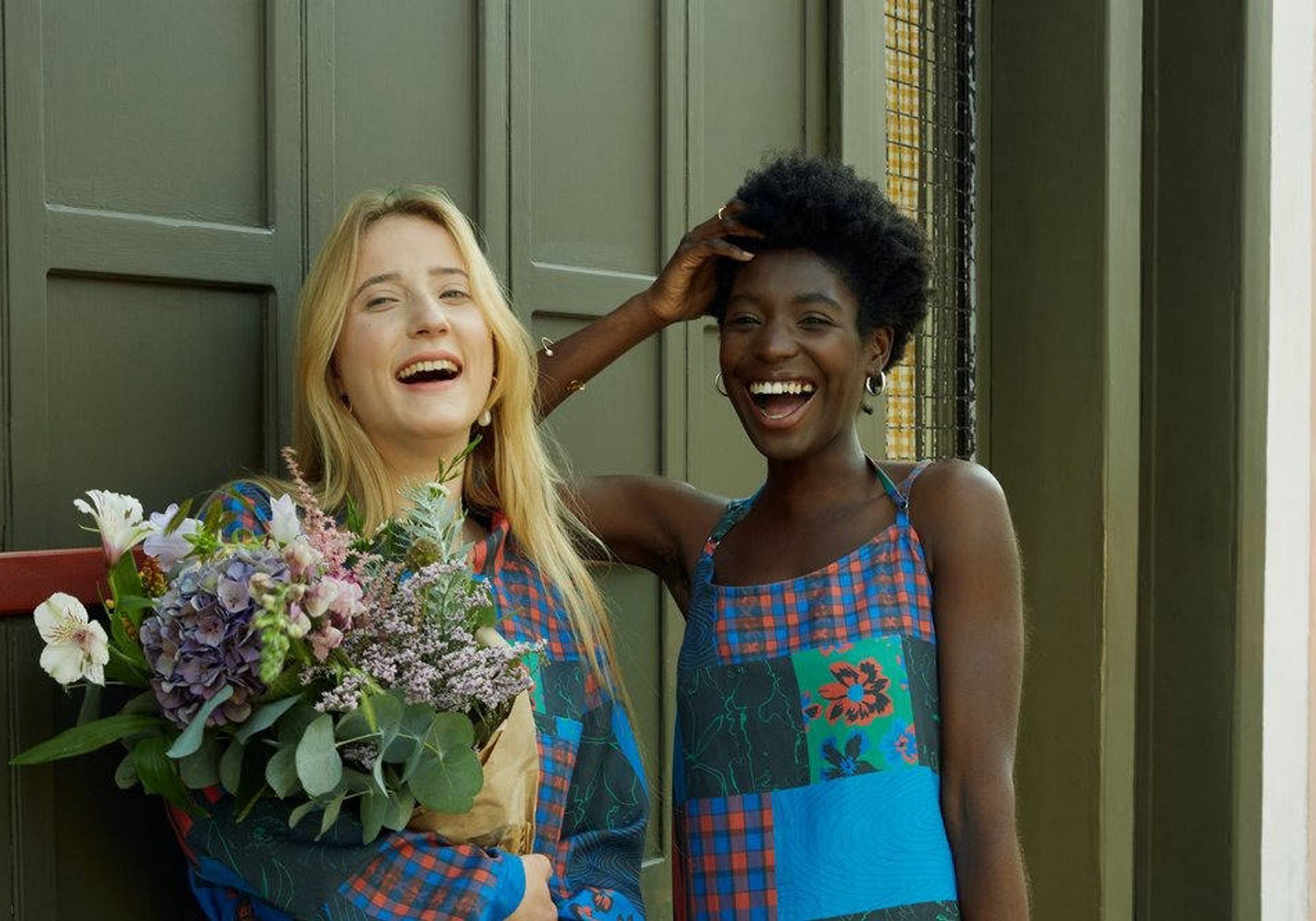 Two women laughing holding flowers