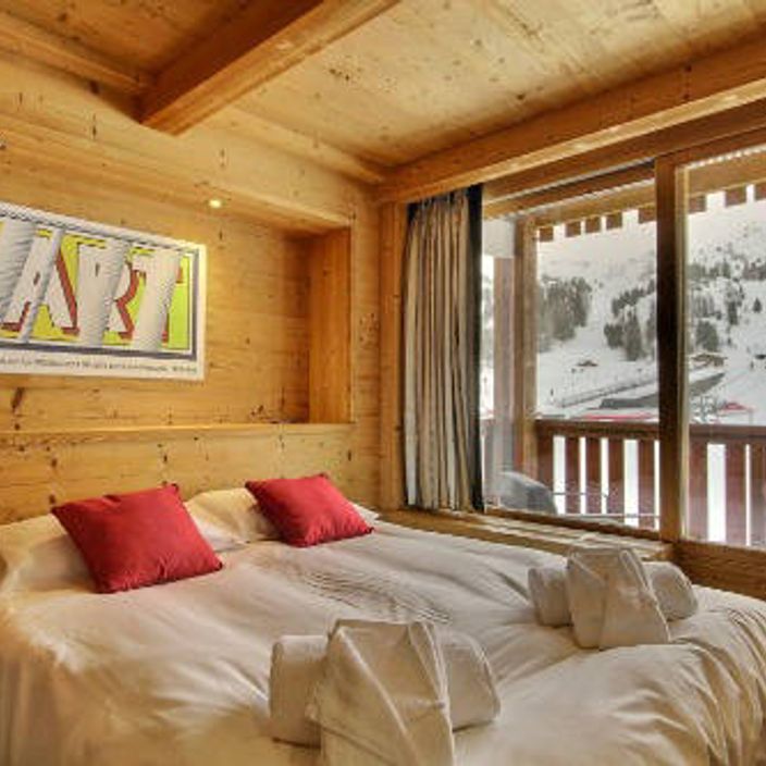 a bedroom of a skiing chalet overlooking the slopes