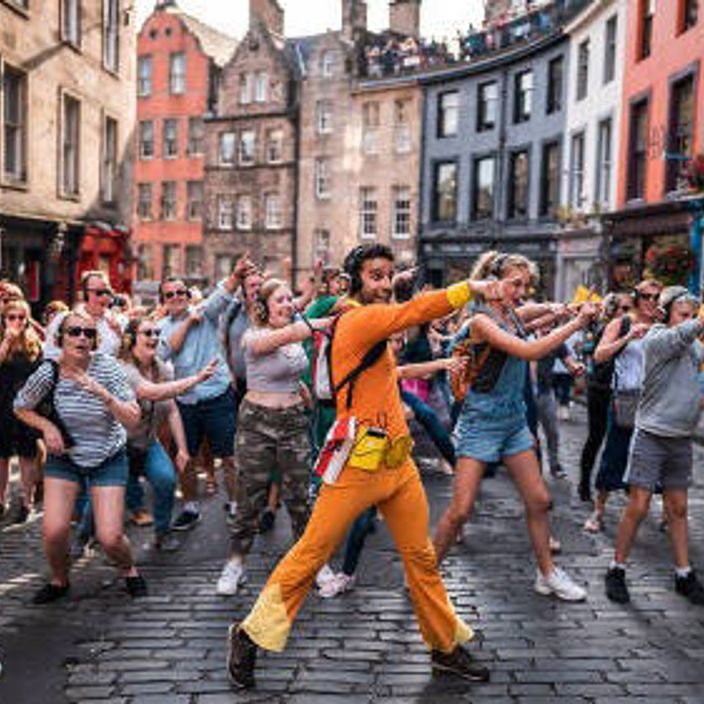 A performer dances with the enthusiastic public in the streets of Edinburgh