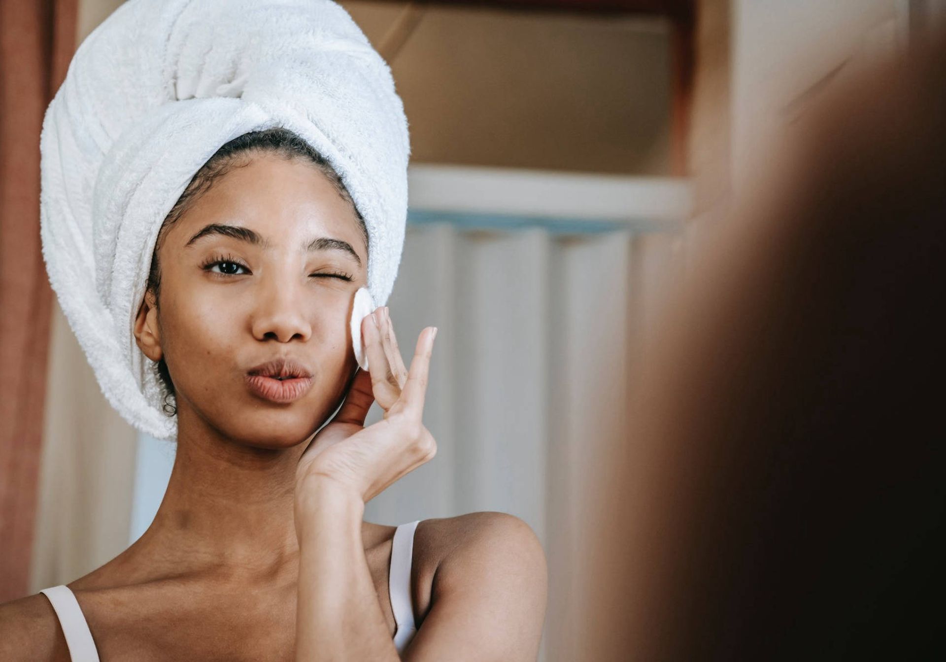 Woman putting skincare on in the bathroom