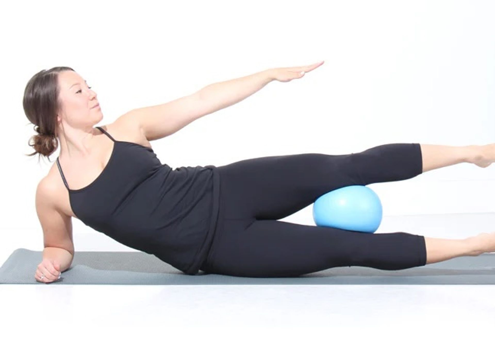 Woman laying using a pilates ball
