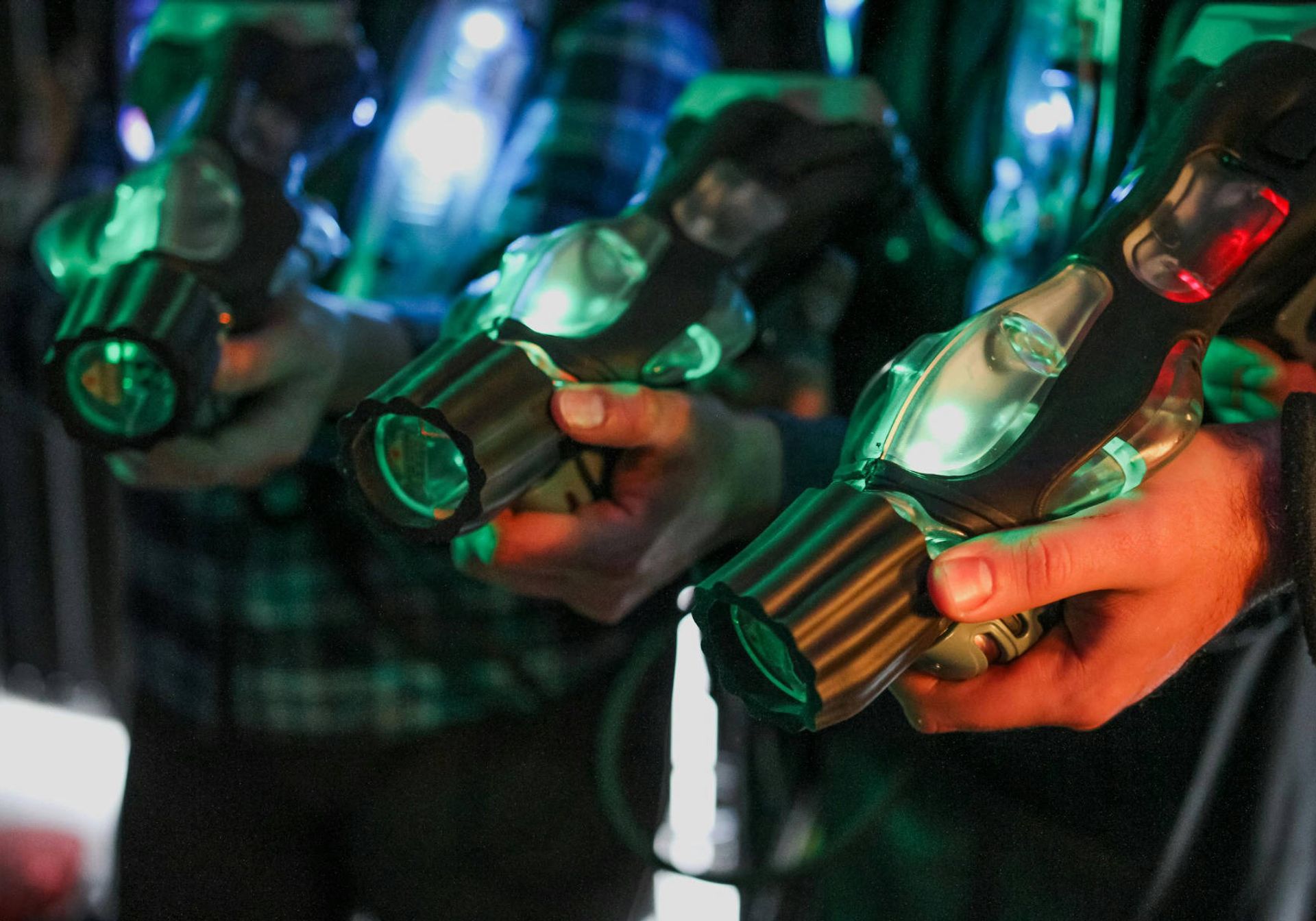 3 hands holding laser tag guns