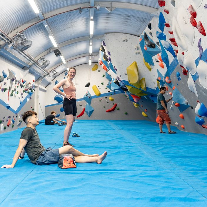 A climber attempts a tricky manoeuvre on a climbing wall