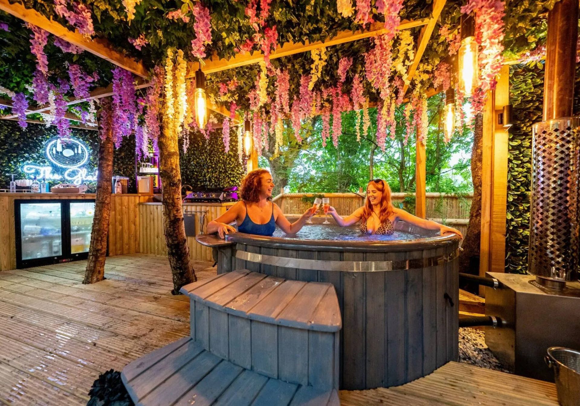 Two people sitting in a hot tub at a glamping location