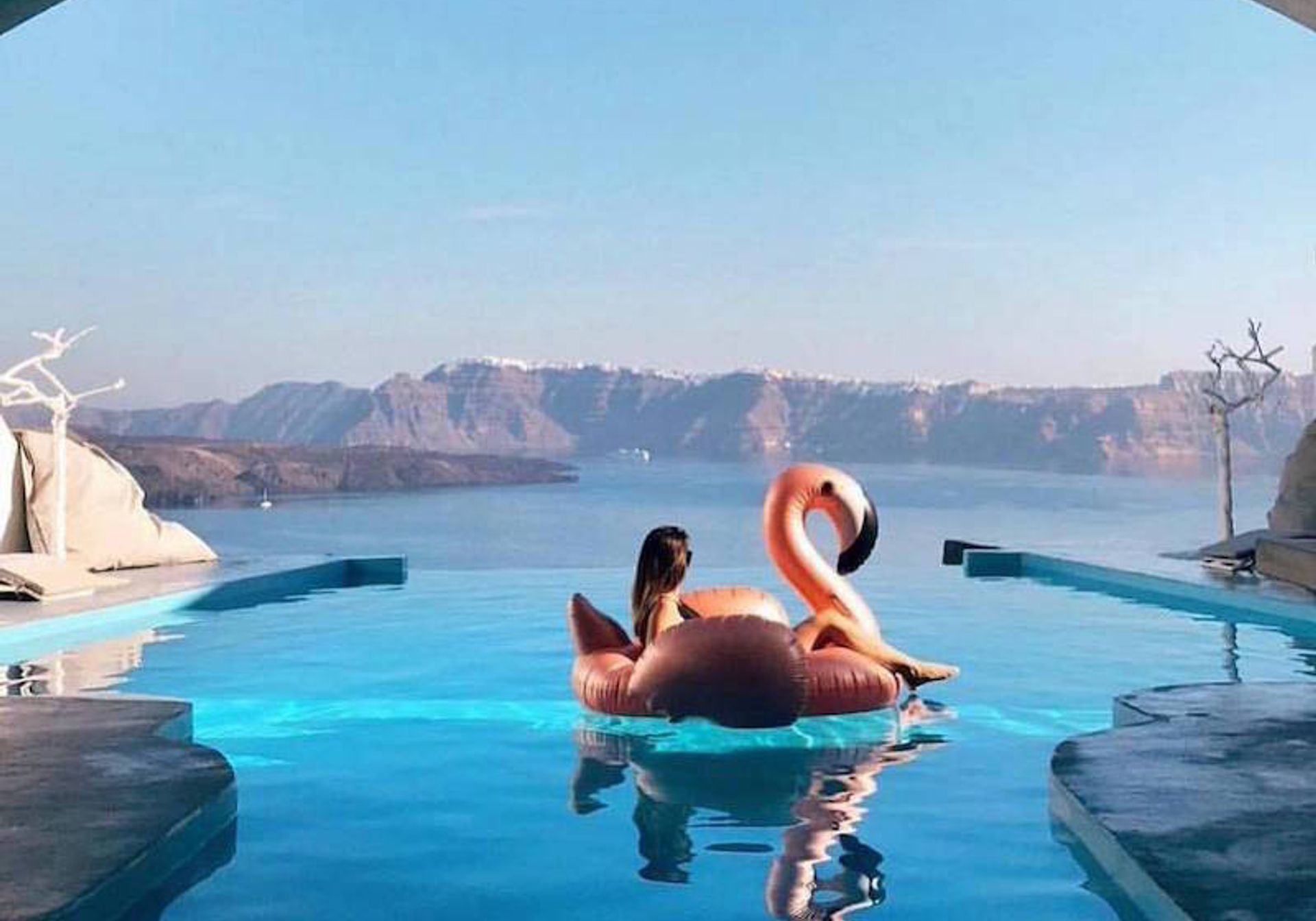 Woman on flamingo on blue sea