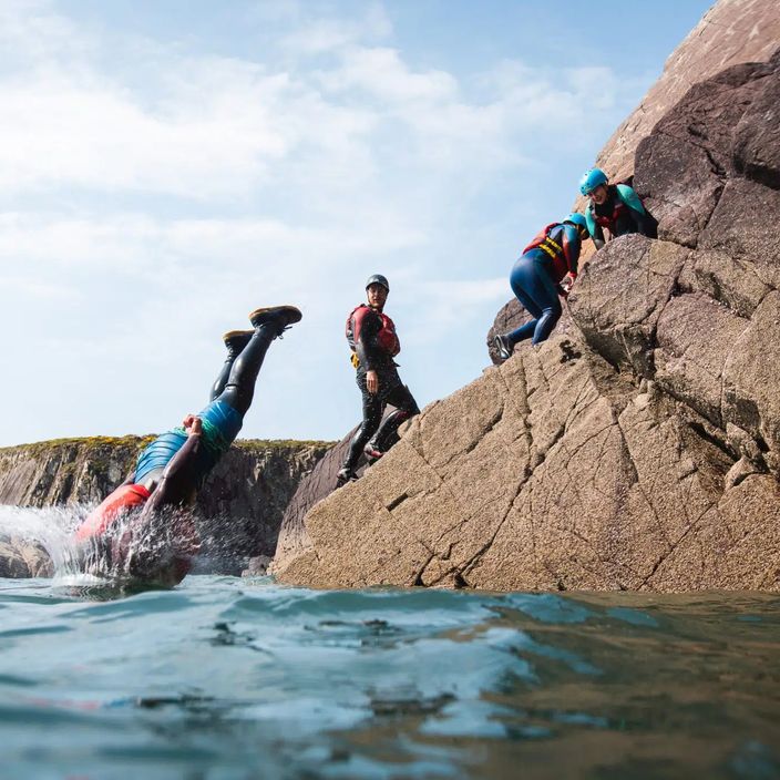 A group of people coasteering