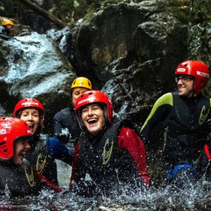 group of smiling people canyoning in wales