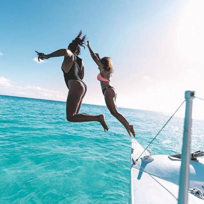Women on a yacht jumping into the sea