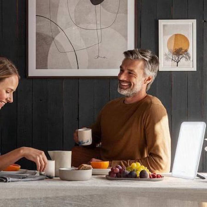 SAD light on a table with two people