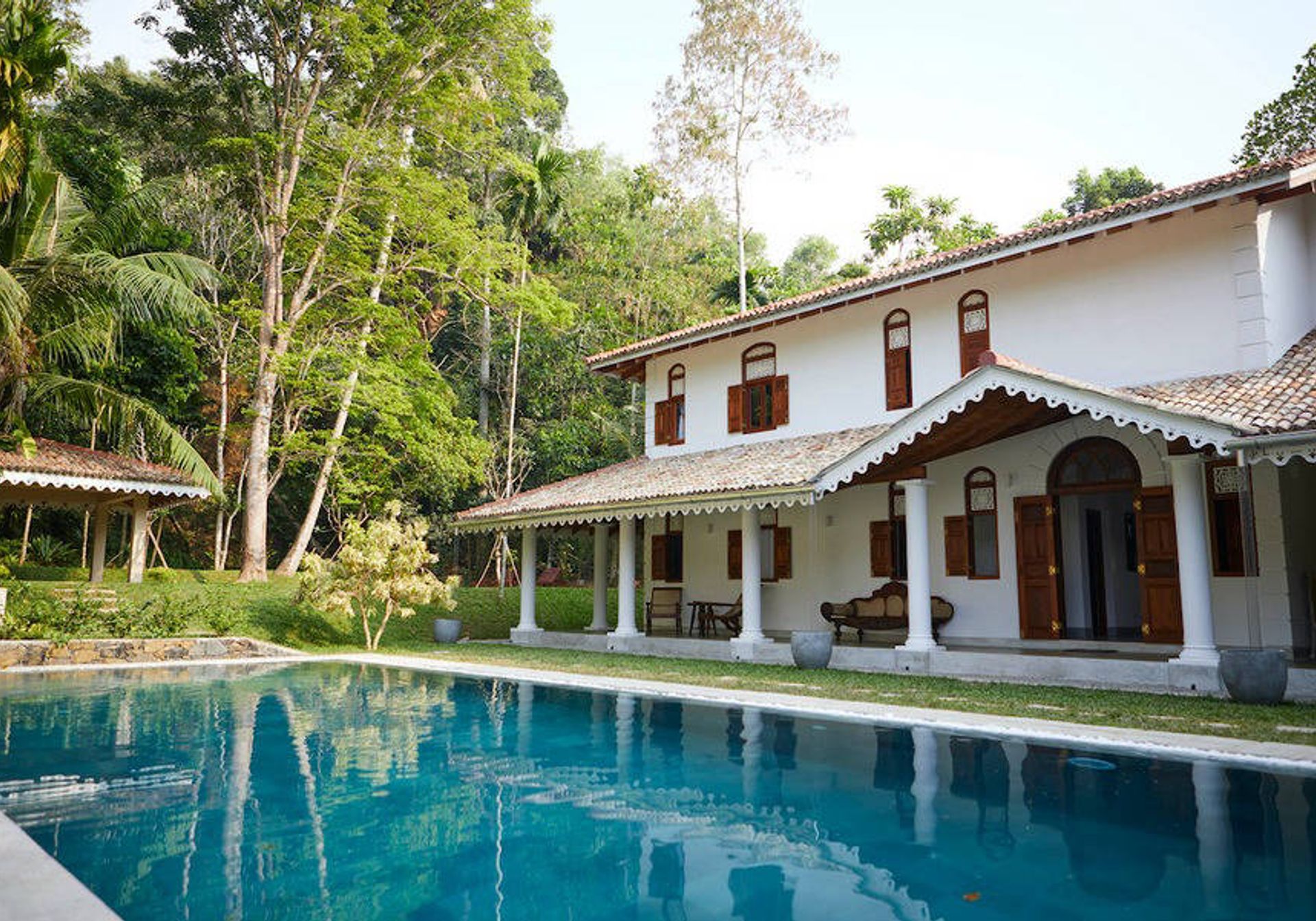 Exterior of Kalukanda House with swimming pool & tropical tree surrounds