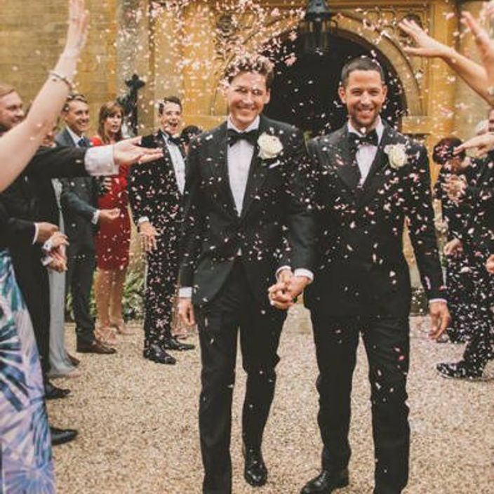 two men walking happy out of chapel after wedding