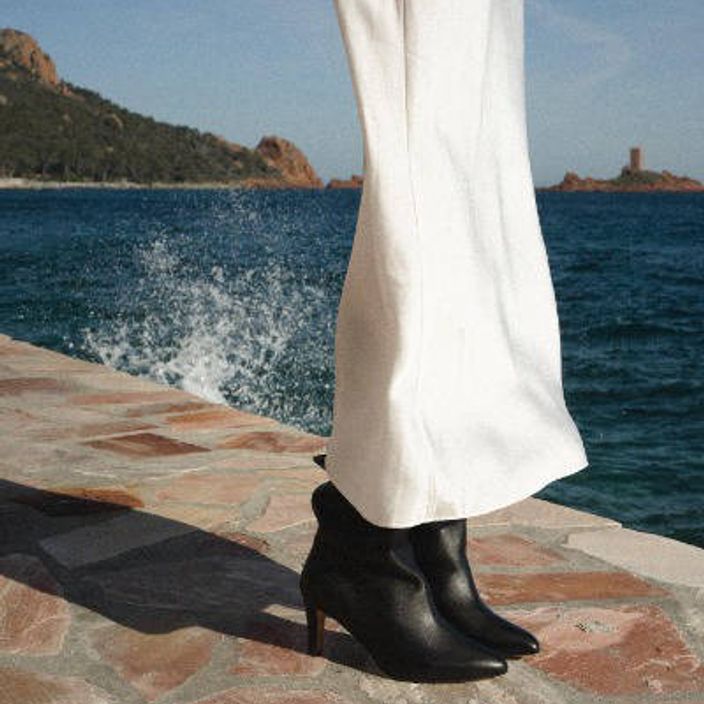 legs wearing anon cph black boots by a lake